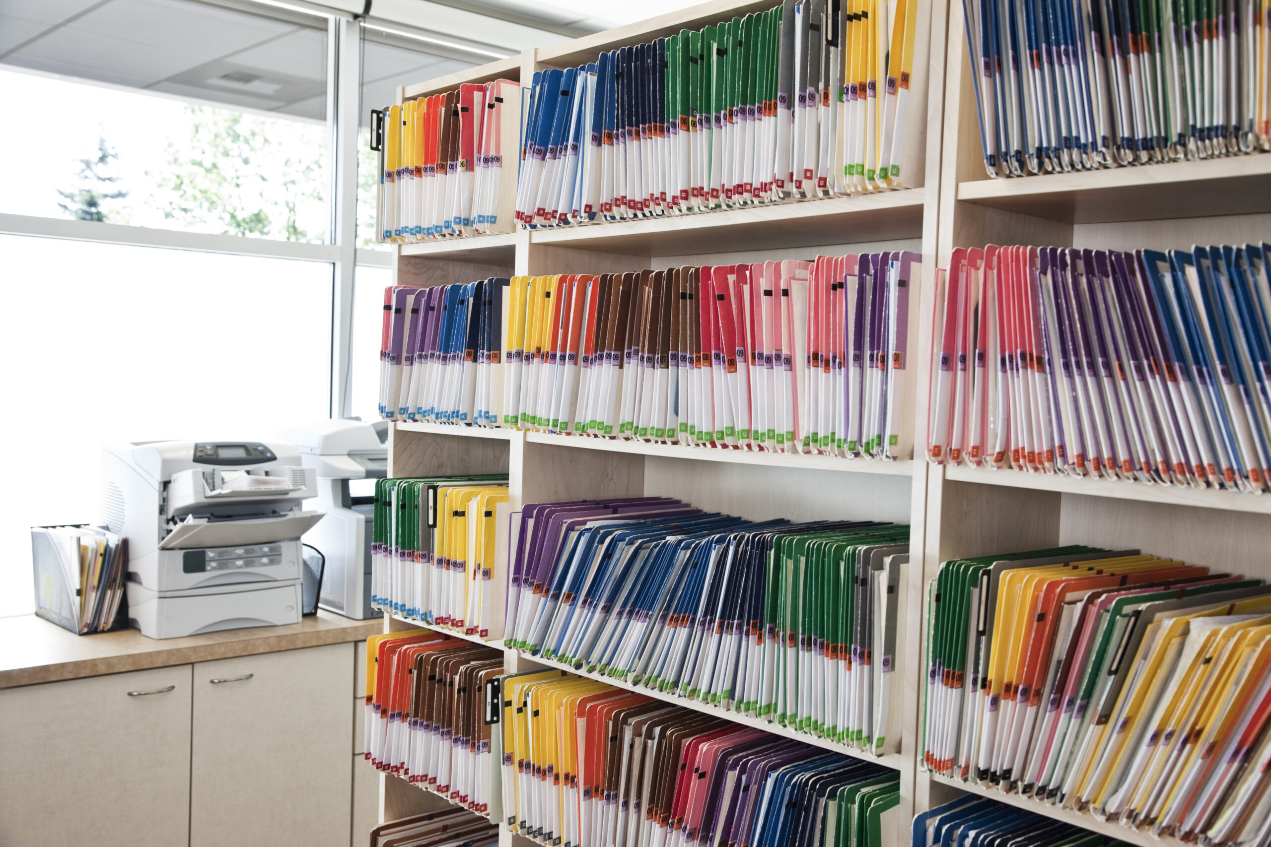 A group of colorful file folders in a dental office.